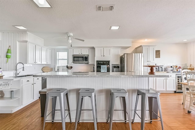 23155 Gulf Dr, Galveston, TX 77554 - kitchen featuring visible vents, white cabinets, stainless steel appliances, and a sink