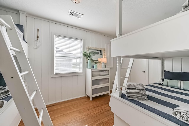 23155 Gulf Dr, Galveston, TX 77554 - bedroom featuring light wood-type flooring, visible vents, and a textured ceiling