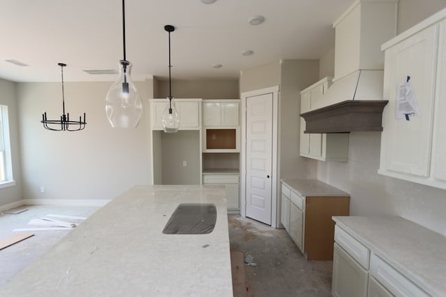 16035 Mason Run Dr, Houston, TX 77079 - kitchen with custom range hood, hanging light fixtures, white cabinets, light stone countertops, and a chandelier