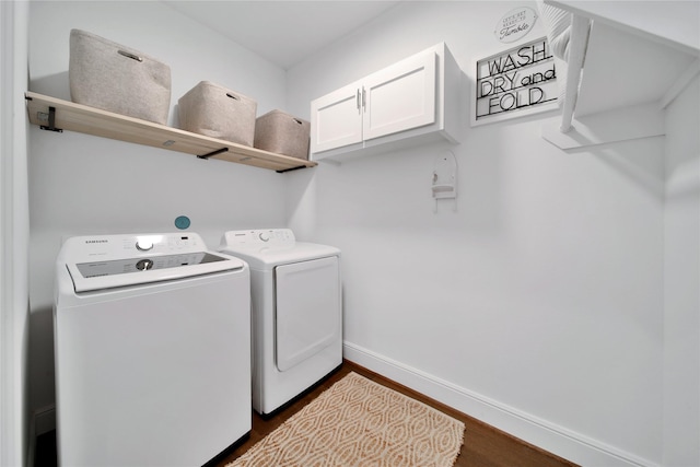 washroom featuring washer and dryer, baseboards, dark wood finished floors, and cabinet space