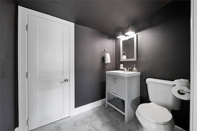 bathroom featuring marble finish floor, vanity, baseboards, and toilet