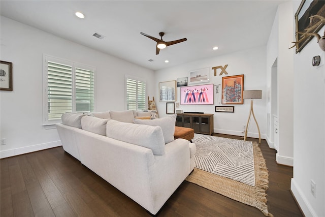living area with visible vents, ceiling fan, baseboards, and dark wood-style floors
