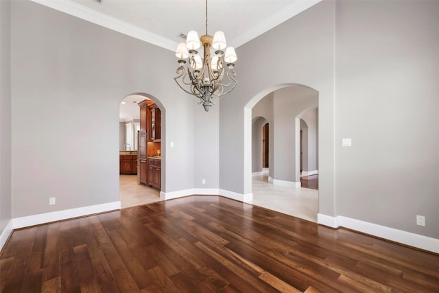 5106 Bellerive Bend Dr, College Station, TX 77845 - empty room featuring light wood-style floors, baseboards, a towering ceiling, crown molding, and a chandelier