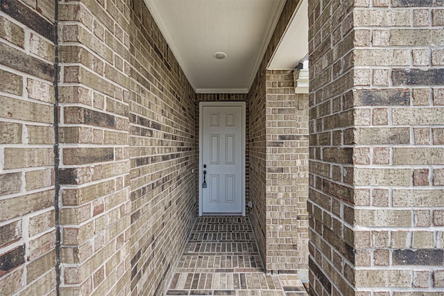 entrance to property featuring brick siding