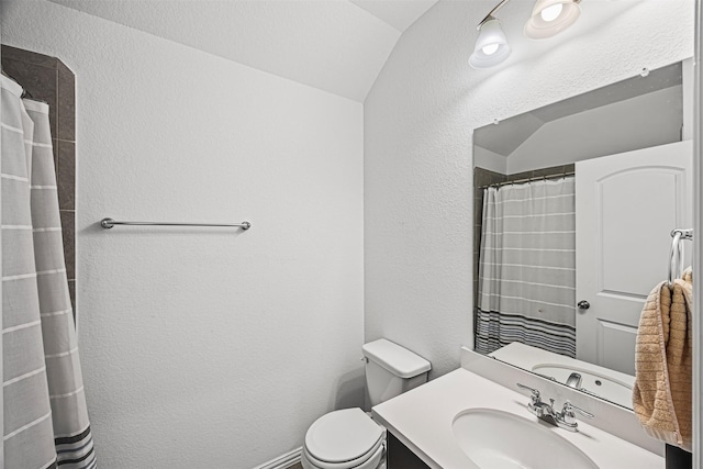 bathroom with toilet, vanity, a textured wall, and lofted ceiling