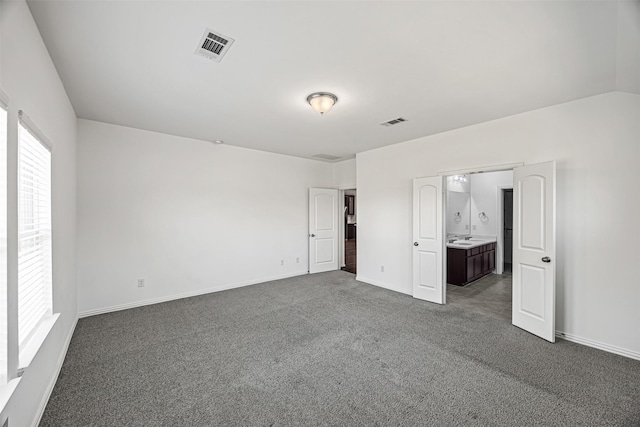 unfurnished bedroom with visible vents, baseboards, carpet, and ensuite bath