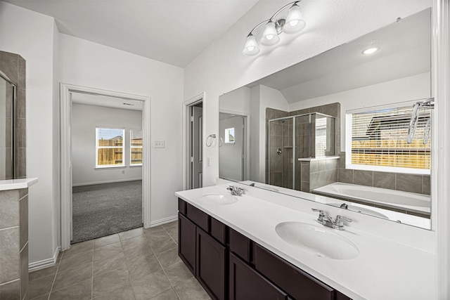 full bathroom featuring a stall shower, double vanity, a sink, and tile patterned flooring