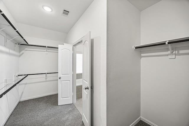 spacious closet featuring light colored carpet and visible vents