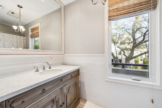 3126 Mid Ln, Houston, TX 77027 - bathroom with vanity, healthy amount of natural light, wainscoting, a chandelier, and tile walls