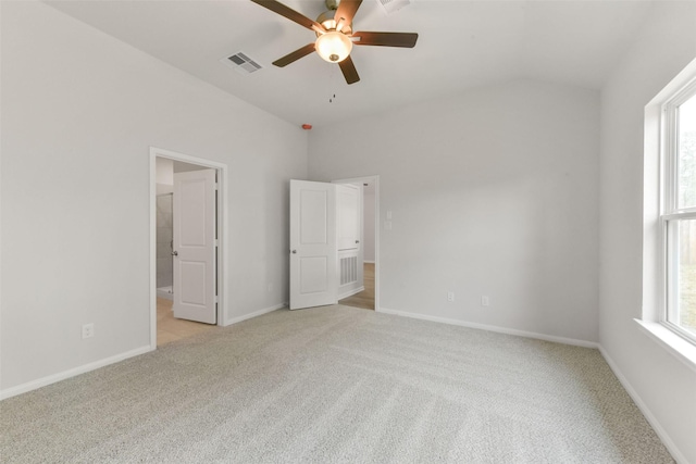 unfurnished bedroom featuring baseboards, visible vents, multiple windows, and light carpet