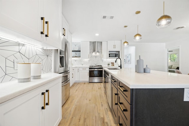 3427 Linkwood Dr, Houston, TX 77025 - kitchen featuring appliances with stainless steel finishes, wall chimney exhaust hood, a sink, white cabinetry, and decorative backsplash