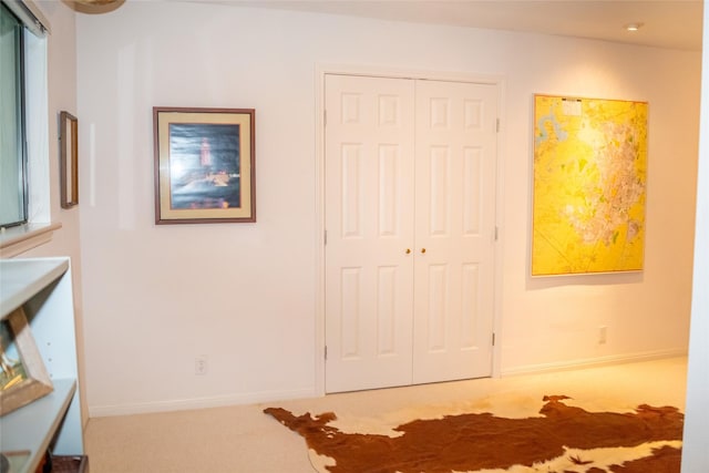 unfurnished bedroom featuring carpet floors, baseboards, and a closet