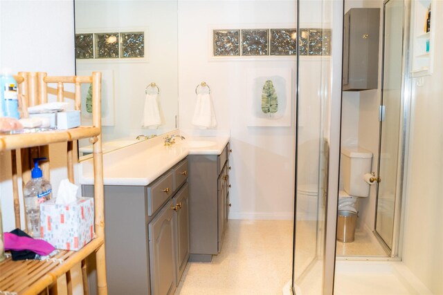 bathroom featuring an enclosed shower, baseboards, and vanity