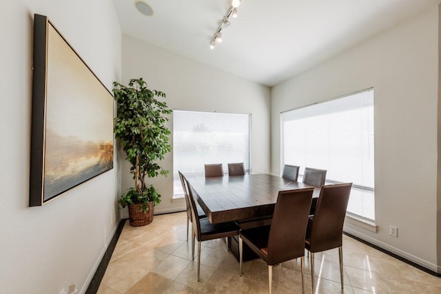 dining room with baseboards, rail lighting, and light tile patterned flooring