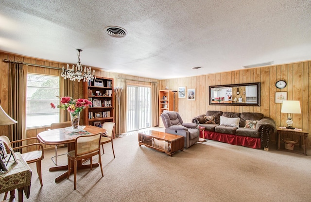 8503 Mcavoy Dr, Houston, TX 77074 - living area with wood walls, visible vents, carpet floors, and a chandelier