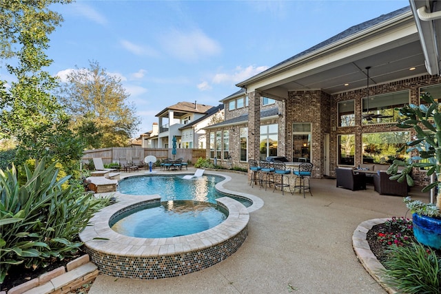view of swimming pool featuring outdoor dry bar, a patio area, an outdoor hangout area, a pool with connected hot tub, and fence