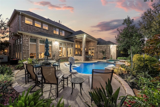 view of swimming pool featuring a patio area and a pool with connected hot tub