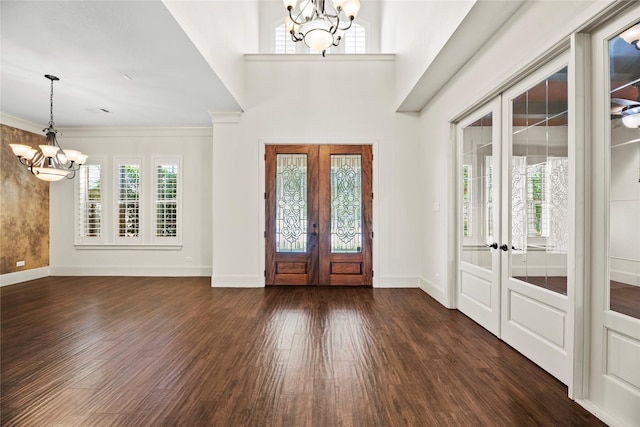 entryway featuring dark wood-type flooring, french doors, baseboards, and a chandelier