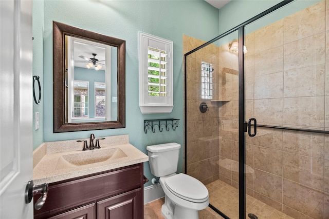 bathroom featuring toilet, ceiling fan, a stall shower, and vanity