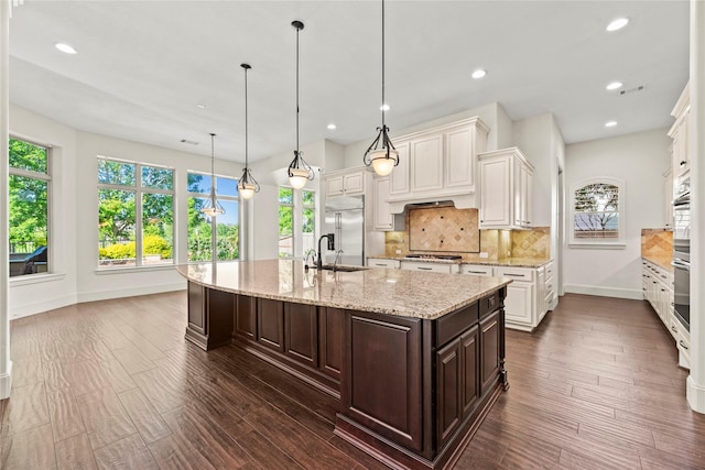 kitchen featuring a sink, baseboards, appliances with stainless steel finishes, and a wealth of natural light