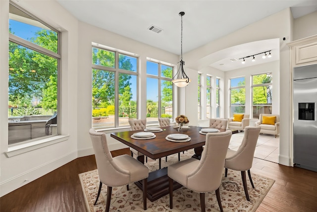 dining space with wood finished floors, baseboards, and visible vents