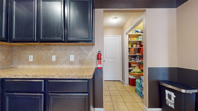 2202 Tandy Park Way, Houston, TX 77047 - kitchen featuring light tile patterned floors, backsplash, and light countertops