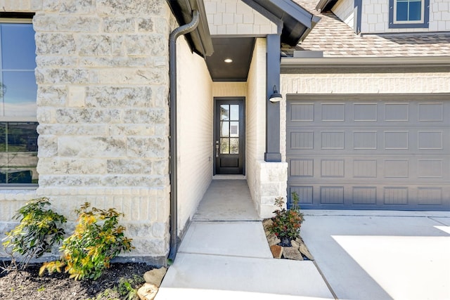 entrance to property featuring stone siding and concrete driveway