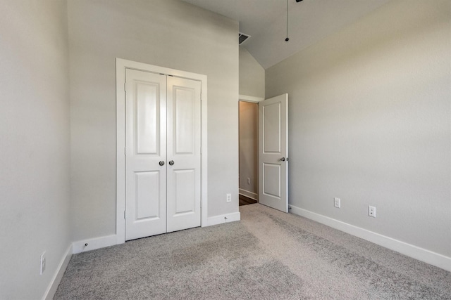 unfurnished bedroom featuring visible vents, baseboards, vaulted ceiling, carpet flooring, and a closet