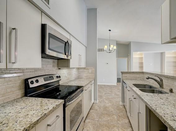 2425 Augusta Dr Unit 60, Houston, TX 77057 - kitchen featuring stainless steel appliances, a sink, backsplash, and white cabinetry