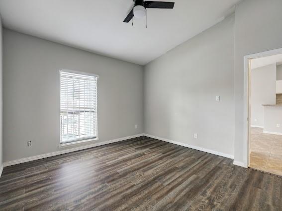 2425 Augusta Dr Unit 60, Houston, TX 77057 - spare room with ceiling fan, dark wood-type flooring, baseboards, and vaulted ceiling