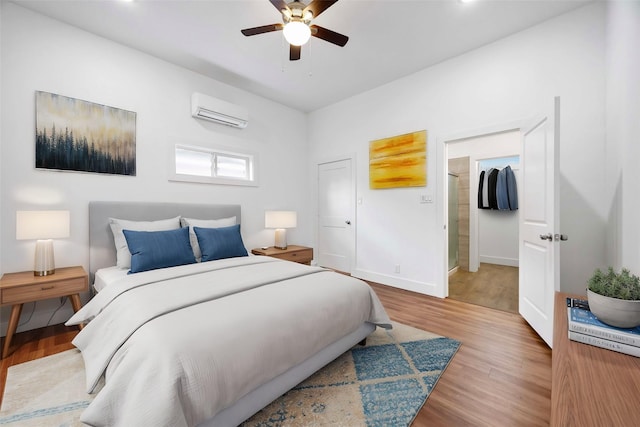 2214 Stevens St, Houston, TX 77026 - bedroom featuring a wall mounted air conditioner, a ceiling fan, light wood-style flooring, and baseboards