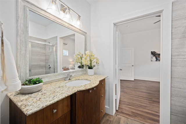 2214 Stevens St, Houston, TX 77026 - full bathroom featuring baseboards, a stall shower, wood finished floors, and vanity