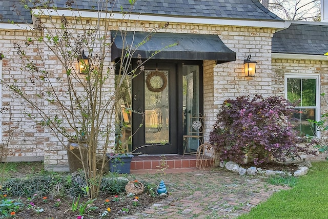 15407 Oaklawn Park Dr, Houston, TX 77069 - view of exterior entry with stone siding, a shingled roof, and brick siding