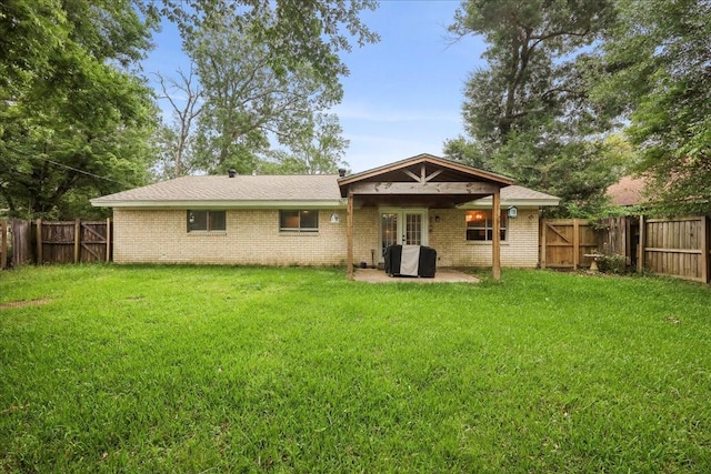 back of house featuring a fenced backyard, a patio area, a yard, and french doors