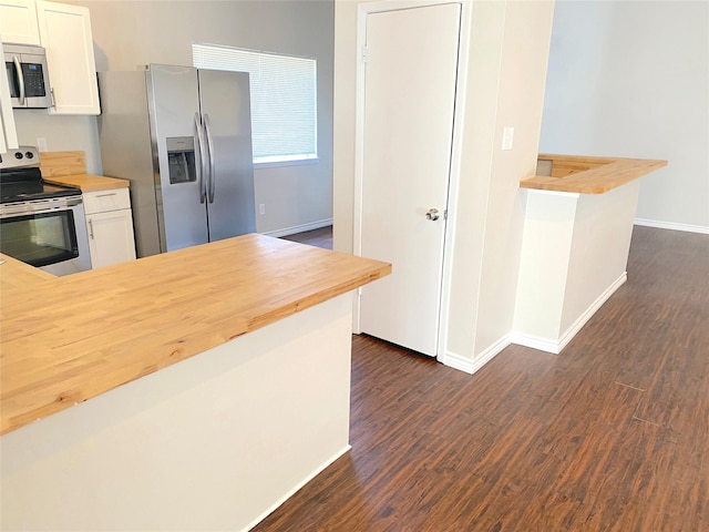 2414 Woven Wood Ln, Richmond, TX 77406 - kitchen with baseboards, dark wood-style floors, white cabinets, stainless steel appliances, and wood counters