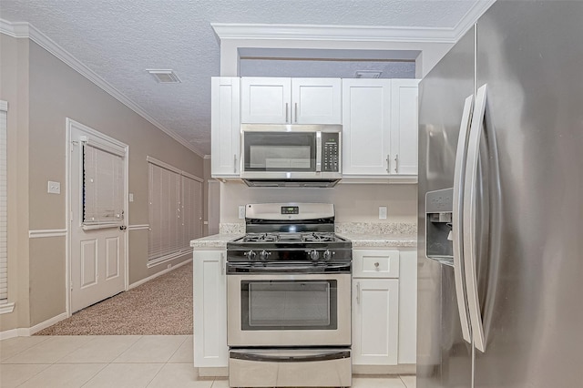 21403 Park Post Ln, Katy, TX 77450 - kitchen featuring appliances with stainless steel finishes, white cabinets, light tile patterned floors, a textured ceiling, and light colored carpet