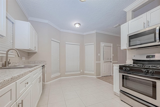 21403 Park Post Ln, Katy, TX 77450 - kitchen with stainless steel appliances, light countertops, white cabinets, a textured ceiling, and crown molding