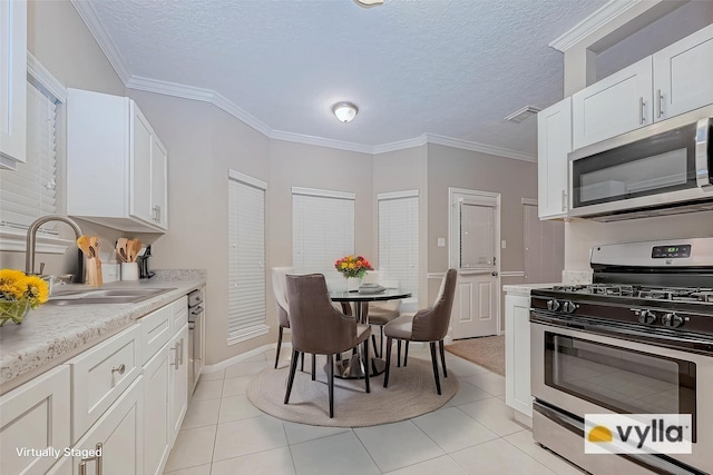 21403 Park Post Ln, Katy, TX 77450 - kitchen with stainless steel appliances, light countertops, white cabinetry, a textured ceiling, and light tile patterned floors