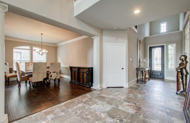 dining area with baseboards, an inviting chandelier, a healthy amount of sunlight, and ornate columns