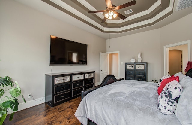 bedroom featuring visible vents, baseboards, ornamental molding, a raised ceiling, and dark wood-style flooring