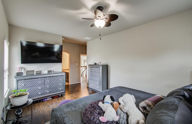bedroom featuring visible vents, arched walkways, ceiling fan, and dark wood-style flooring