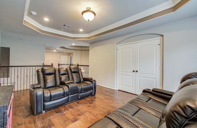 cinema room with visible vents, crown molding, recessed lighting, wood finished floors, and a raised ceiling