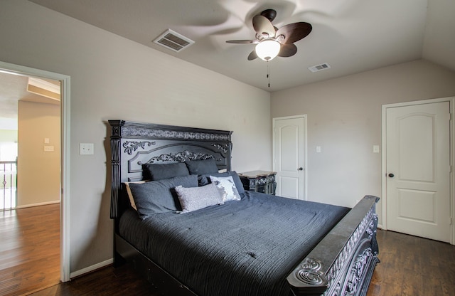 bedroom featuring vaulted ceiling, visible vents, baseboards, and wood finished floors