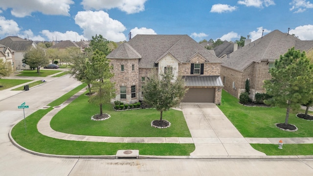french country home featuring brick siding, an attached garage, concrete driveway, and a front lawn