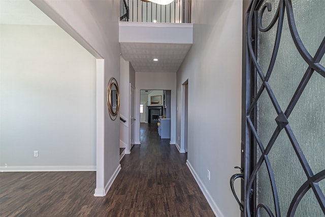 hallway featuring baseboards and dark wood finished floors