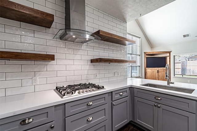 kitchen featuring open shelves, lofted ceiling, a sink, gray cabinetry, and backsplash