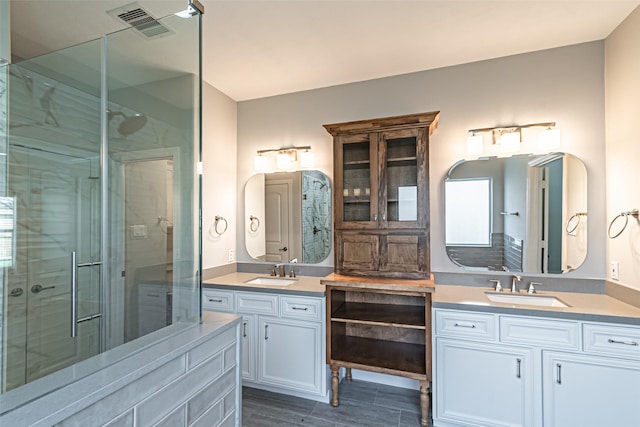 bathroom with wood tiled floor, visible vents, vanity, and a shower stall