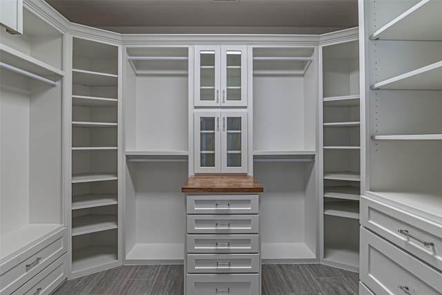 walk in closet with wood finish floors