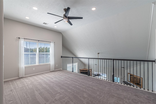 empty room with visible vents, baseboards, lofted ceiling, carpet floors, and a ceiling fan