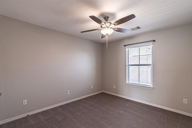 empty room with visible vents, baseboards, a ceiling fan, and dark colored carpet